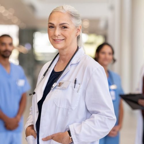 Portrait of mature female doctor on hospital corridor. Confident