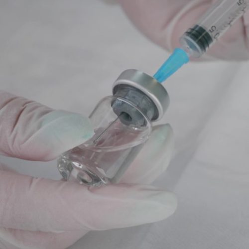 A Sterile Drug Is Taken In Gloves With A Syringe From A Glass Vi